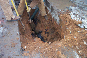 Workers digging in the ground to find a water leak.